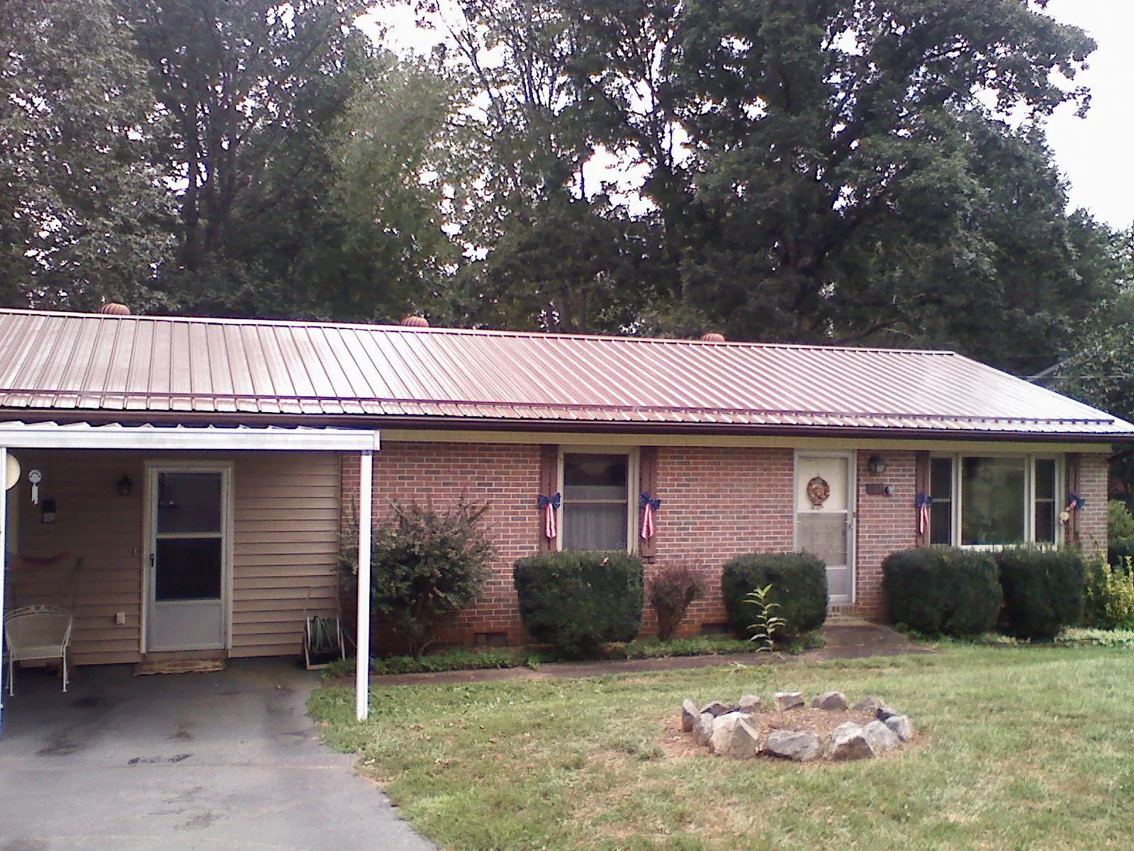 Bronze metal roof and carport on a brick ranch home — Roof Repair work by our crew in Lake Charles