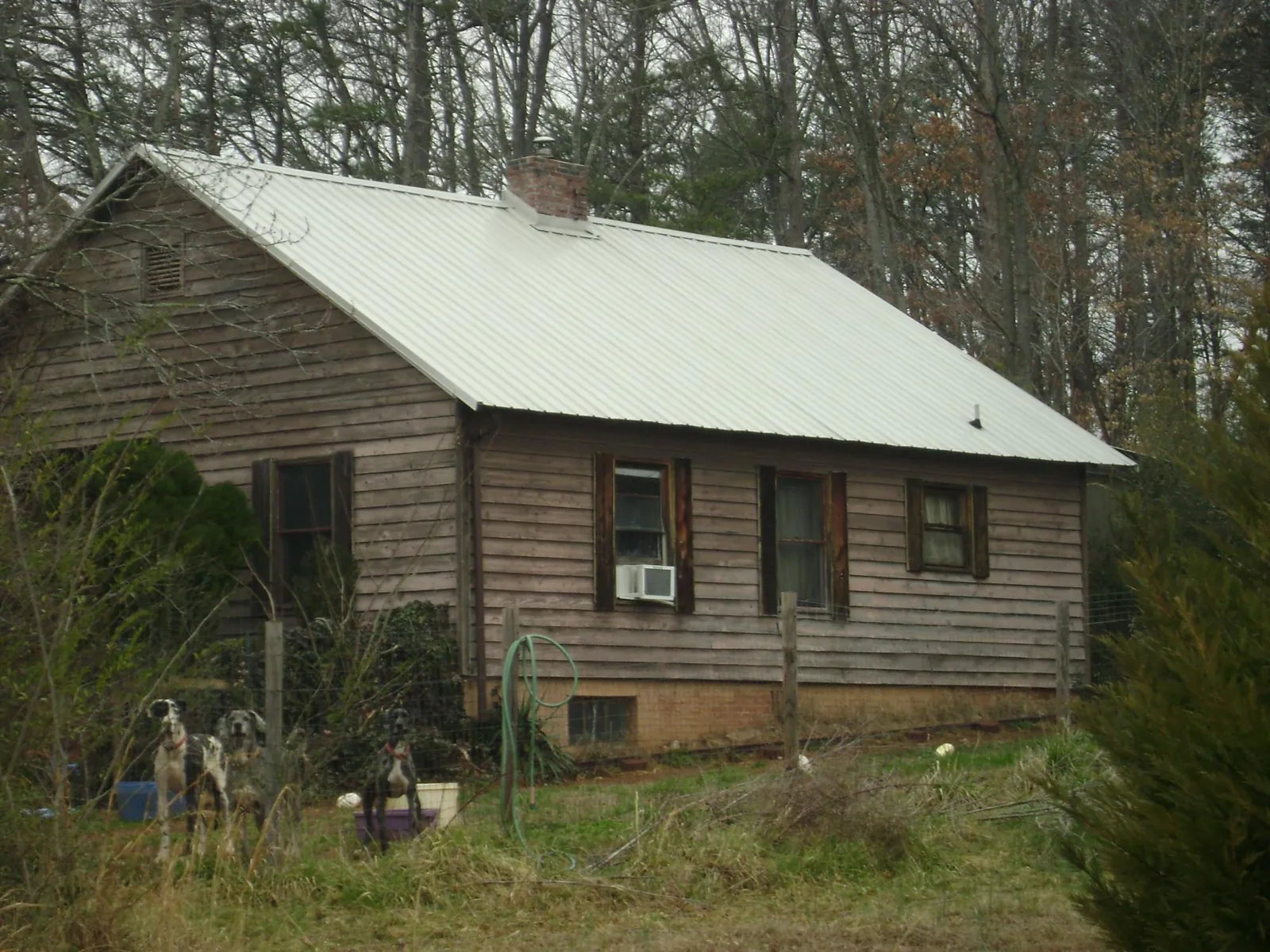 White metal roof on an old wood sided farmhouse, from a Metal Roof Installation job in Lake Charles